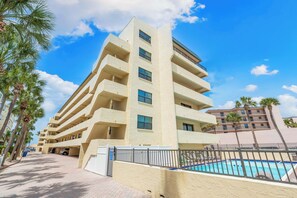 A multi-story hotel with balconies, a swimming pool, and palm trees. - Sea Shell by Beachside Management (Siesta Key)
