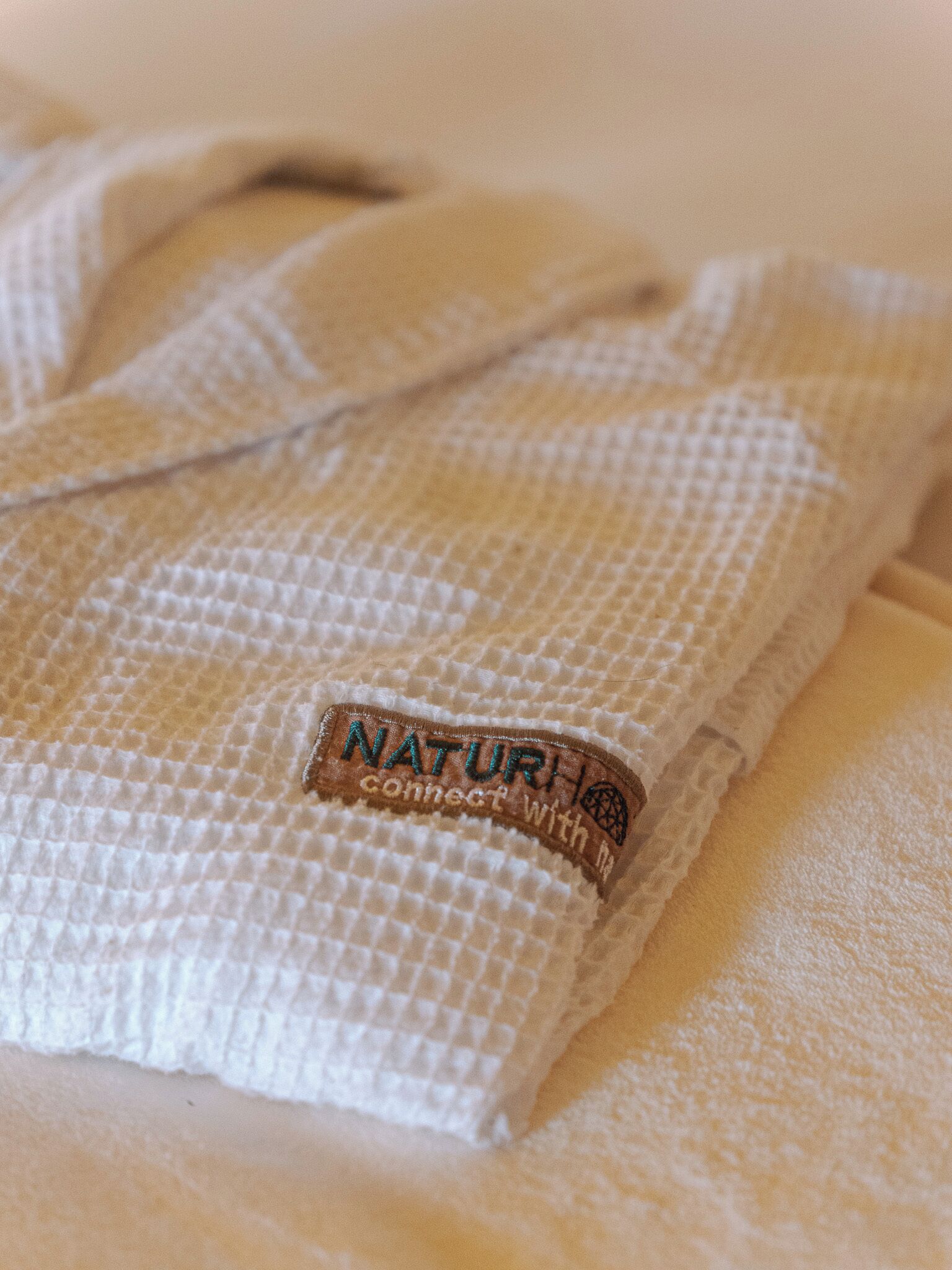 Una toalla doblada con una etiqueta que dice 'NATURI conecta con la naturaleza'.