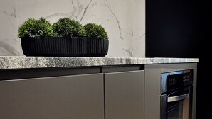 Eine moderne Küche mit Einbauofen und einer schwarzen Arbeitsplatte.