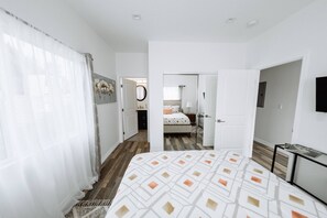 Relax in a spacious room with a large bed, flat-screen TV, and a bedside table with a lamp.