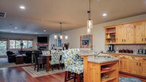 Una cocina moderna con armarios de madera, una isla central e iluminación colgante.