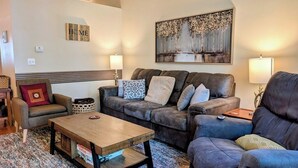 A living room with a sofa set, a coffee table, and a painting on the wall.
