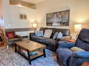 A living room with a sofa set, a coffee table, and a painting on the wall.