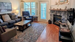 A living room with a fireplace, a sofa set, a coffee table, and a rug.