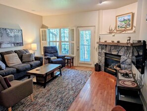 A living room with a fireplace, a sofa set, a coffee table, and a rug.