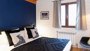 A bedroom with a bed, a black headboard, a window with curtains, a radiator, and a chair. - Riverfront Retreat by Grandvalira & Parking

 (Canillo)
