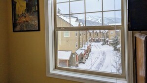 A window with a view of a snowy street and buildings. - Chalet 135 at the Official Collins Lake Resort (Government Camp)