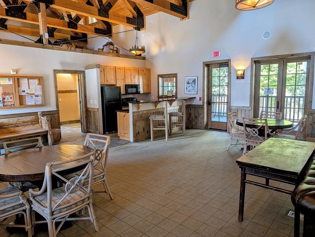 Un intérieur rustique avec des meubles en bois, un coin cuisine et un espace salon avec des tables et des chaises.
