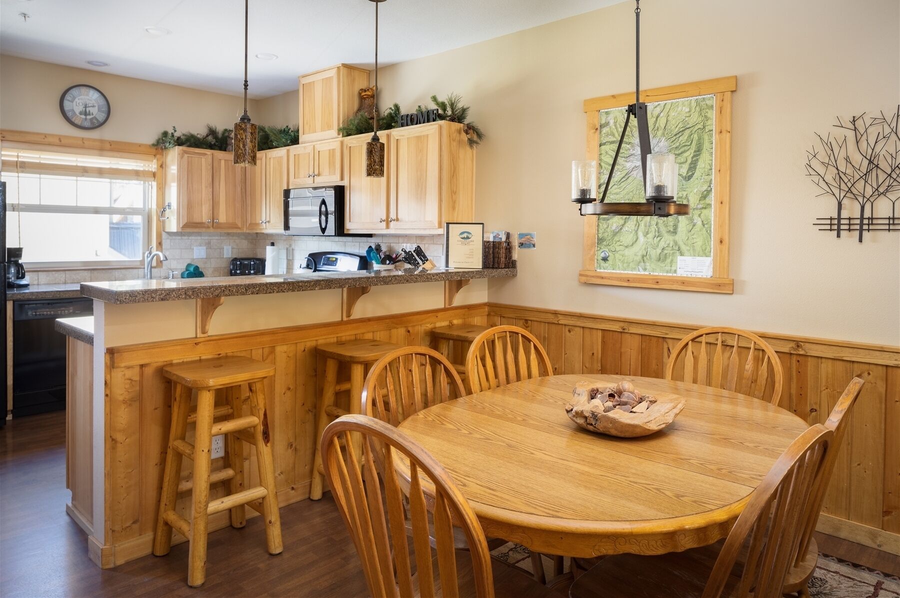 A kitchen with wooden cabinets, a microwave, and a dining area with a wooden table and chairs.