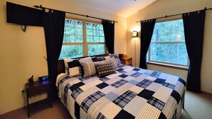 A bedroom with a bed, a nightstand, a ceiling fan, and two windows with curtains. - Chalet 106 at the Official Collins Lake Resort (Government Camp)