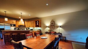 A spacious kitchen with wooden cabinets, a central island, and pendant lighting.