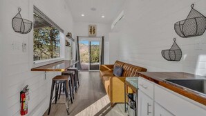 A modern kitchen with a wooden countertop, a built-in oven, and a window overlooking a scenic view. - Lake Simtustus Resort Juniper Hill Tiny Home #11 - Hot Tub (Madras)