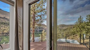 A wooden deck with a glass door leading to a scenic view of a lake and mountains. - Lake Simtustus Resort Juniper Hill Tiny Home #11 - Hot Tub (Madras)