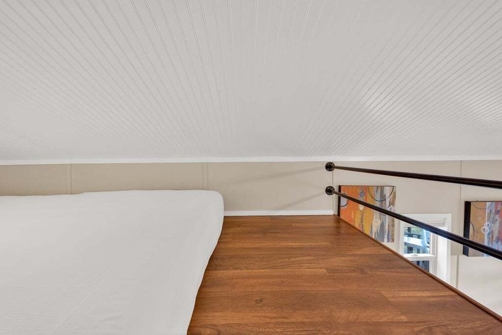A modern room with a wooden floor, white walls, and a white ceiling.