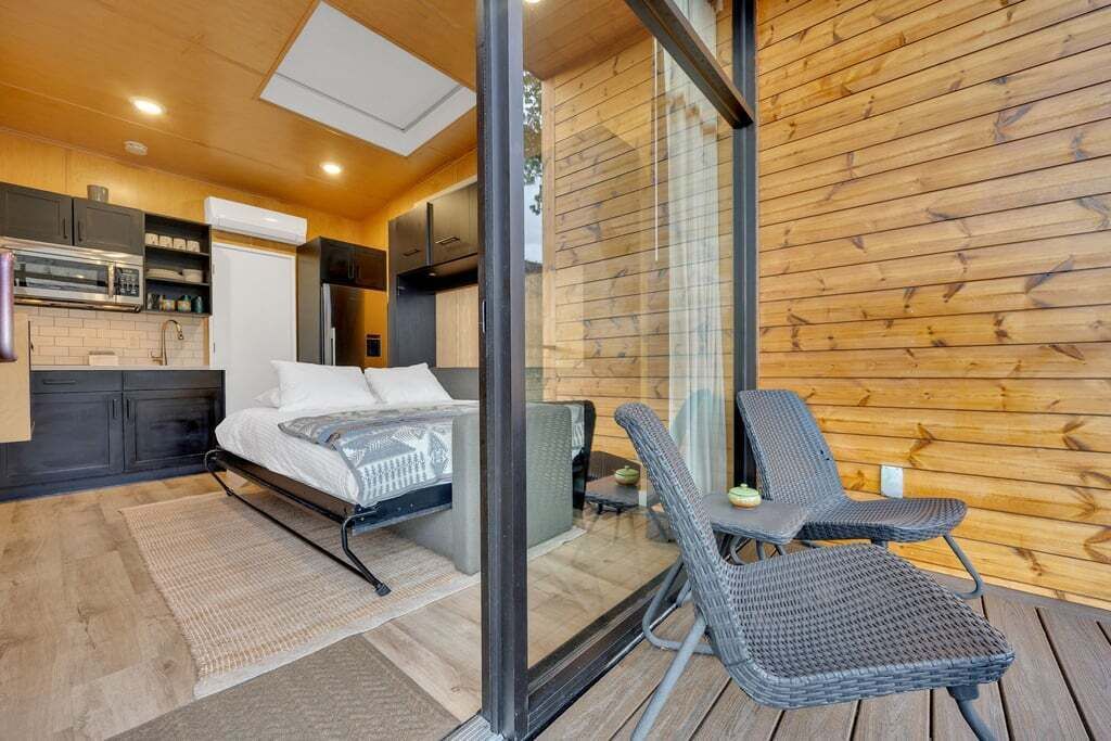 A modern bedroom with a bed, a small table, and a chair.