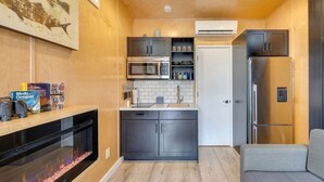 Una cucina compatta con forno a microonde, forno, frigorifero, un piccolo lavello e lavastoviglie.