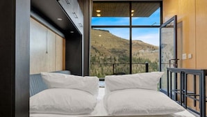 Un dormitorio con un ventanal que ofrece vistas a la montaña.