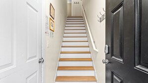 Una escalera con escalones blancos y de madera que conduce a una plataforma.