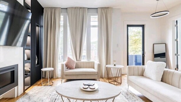 A modern living room with a sofa, a coffee table, and a fireplace. - Stunning Home Getaway
Modern house with a rooftop / 6 minute from Broadway (Nashville)
