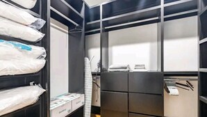 A walk-in closet with multiple shelves and drawers, containing neatly folded clothes and storage boxes. - Stunning Home Getaway
Modern house with a rooftop / 6 minute from Broadway (Nashville)