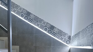 A staircase with a patterned border and grey tiles. - Casa Familiar (San Fernando)