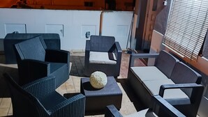 An outdoor seating area with wicker furniture and a decorative ball. - Casa Familiar (San Fernando)