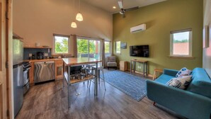 Una cocina moderna con comedor, una sala de estar con sofá y televisor.