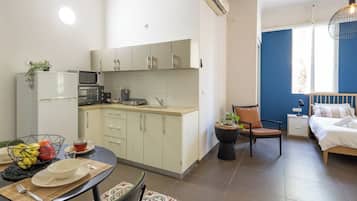 Un espacio habitable compacto con kitchenette, comedor y dormitorio.