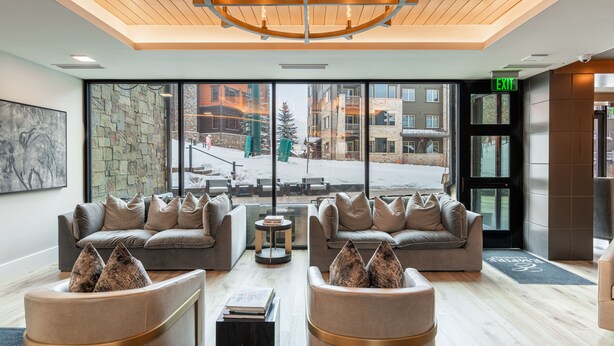 Eine moderne Lobby mit zwei Sofas, einem Couchtisch und einem Kronleuchter.