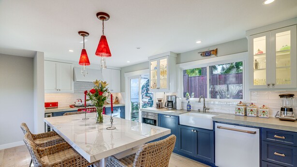 A modern kitchen with a central island, wicker chairs, and red pendant lights. - Seascape Aptos Retreat w/ Bocce Ball Court! (Aptos)