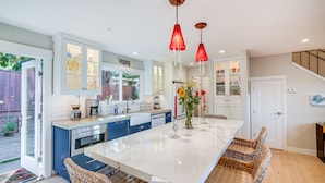 A modern kitchen with a large island, blue cabinets, and a white countertop. - Seascape Aptos Retreat w/ Bocce Ball Court! (Aptos)