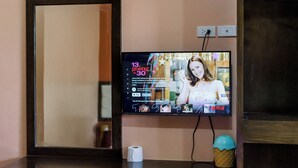 A television mounted on a wall displaying a movie selection interface. - Alona Princess Suites (Panglao)