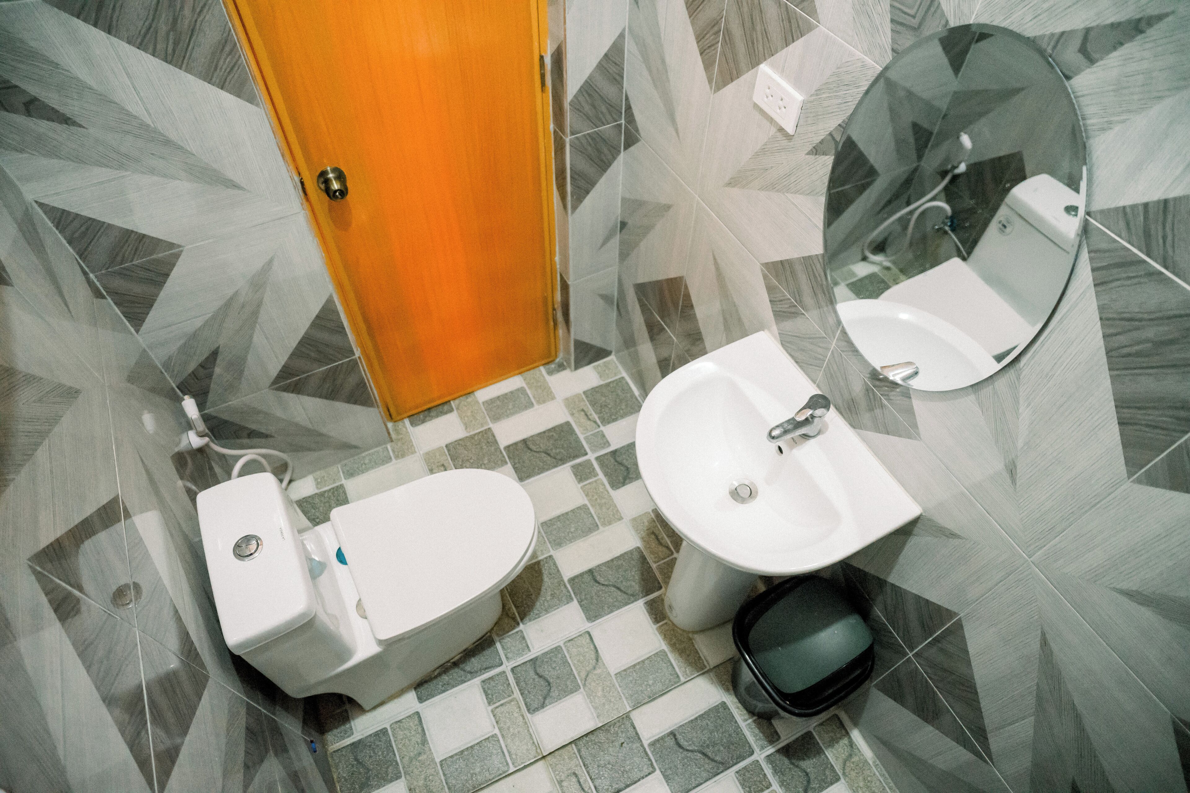 A bathroom with a toilet, bidet, sink, and mirror.
