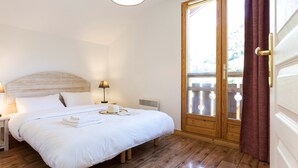 Un lit bien fait, avec du linge de lit blanc, une lampe de chevet et une tête de lit en bois.