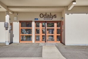 A building entrance with a sign reading 'Odalys Vacances' and a ramp leading up to the door.