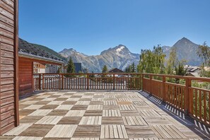 A wooden deck with a view of mountains.