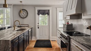 A modern kitchen with a marble countertop, a built-in oven, and a stainless steel range hood. - Huge Mod Farmhouse Pets Hot Tub Firepit | 11 Min to ShenNatl or Massanutten Park (Elkton)