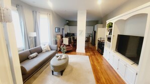 A living room with a sofa, ottoman, and TV stand. - Huge Mod Farmhouse Pets Hot Tub Firepit | 11 Min to ShenNatl or Massanutten Park (Elkton)
