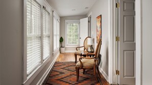 A hallway with a patterned rug, a chair, a lamp, and a door. - Huge Mod Farmhouse Pets Hot Tub Firepit | 11 Min to ShenNatl or Massanutten Park (Elkton)