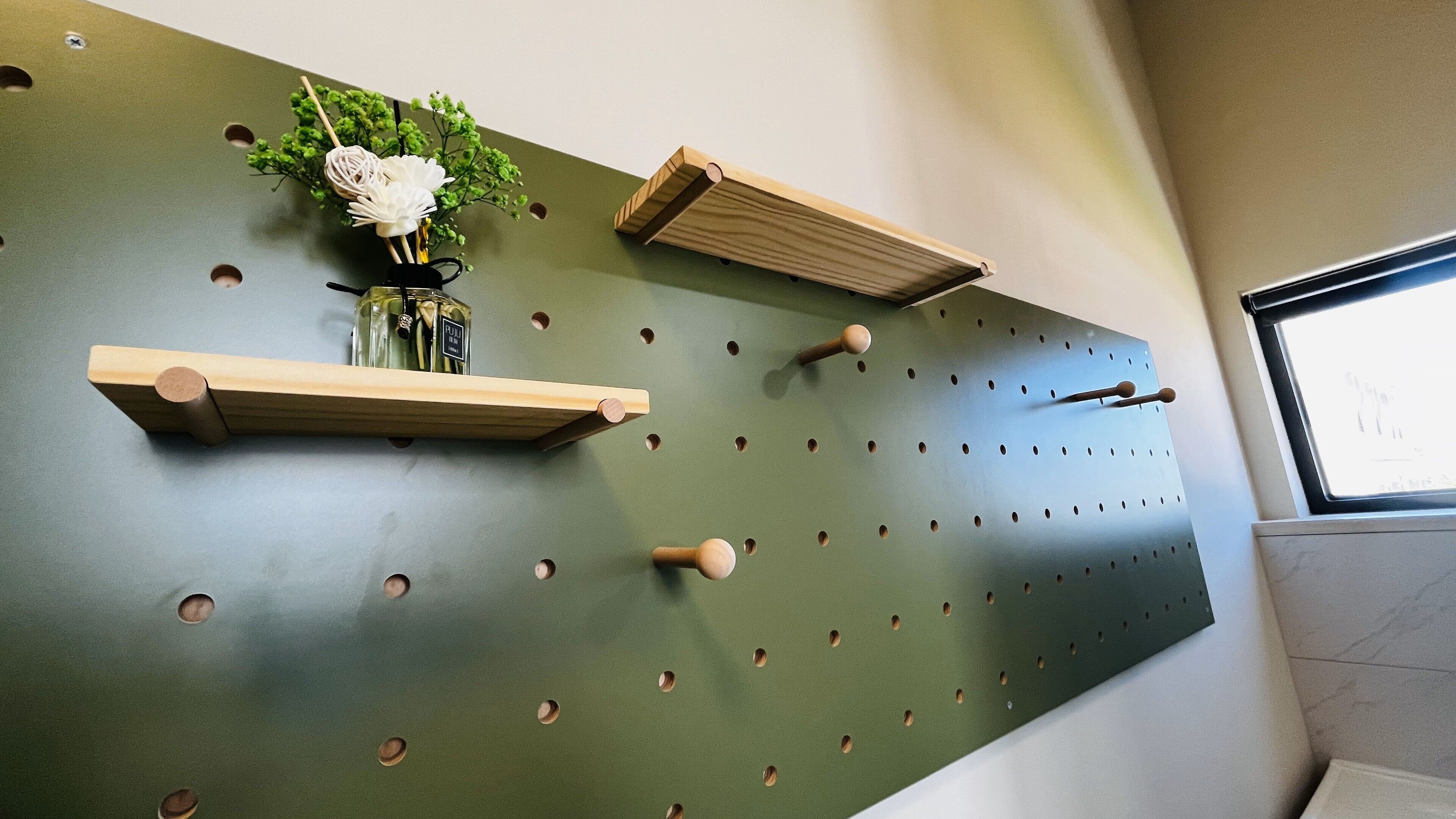 A wall with pegboards and wooden shelves.