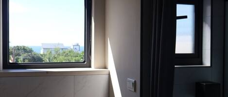 Un baño con ventana, lavamanos y retrete.
