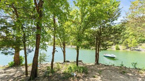 Un cadre paisible au bord d’un lac, avec des arbres et un bateau sur l’eau.