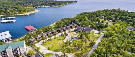 An aerial view of a residential area with houses, a swimming pool, and a dock.