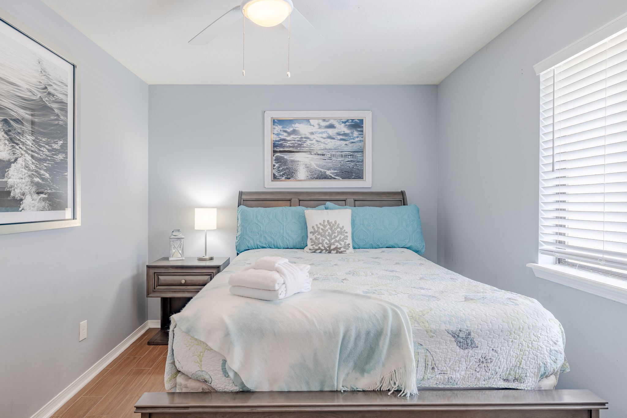 Une chambre à coucher avec un lit, une table de chevet et un tableau encadré accroché au mur.