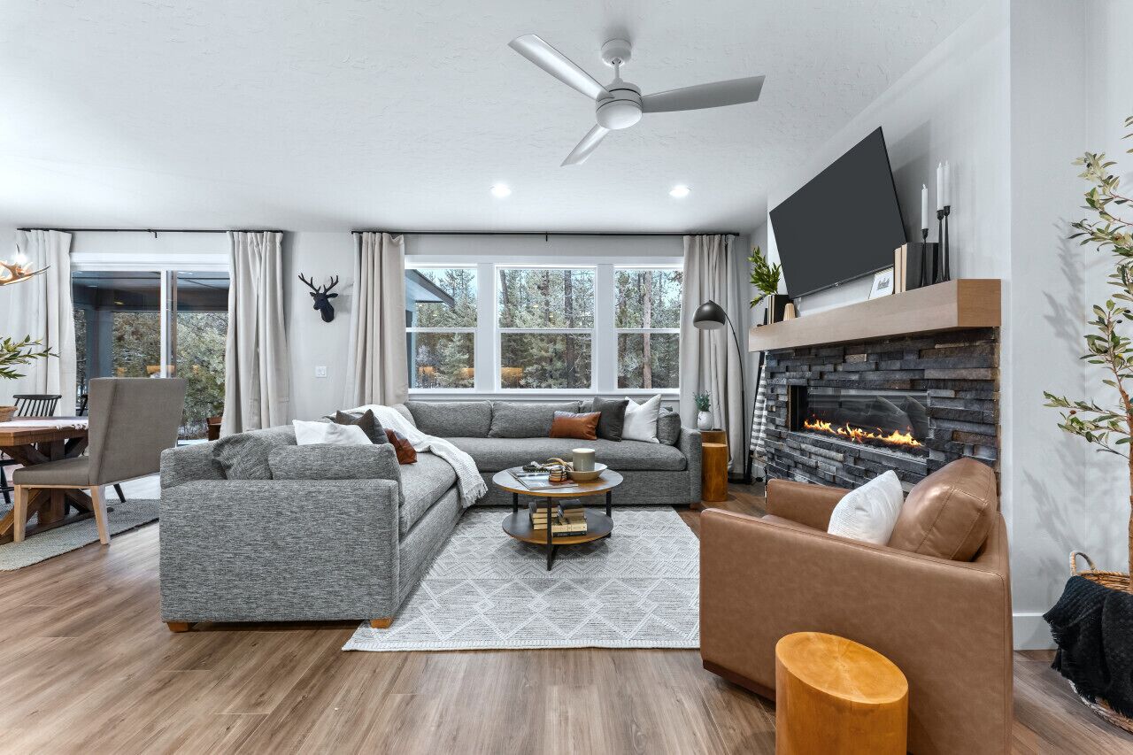 A modern living room with a fireplace, grey sofas, a coffee table, and a TV.