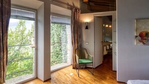 A room with large windows, a chair, and a bathroom visible through an open door. - Stunning private villa with A/C, private pool, WIFI, TV, terrace, panoramic view, close to Viareggio (Camaiore)