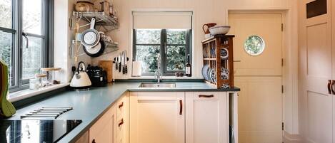 A kitchen with a window, a sink, and a dining area with a checkered tablecloth.