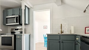 A modern kitchen with grey cabinets, stainless steel appliances, and a white tiled backsplash. - Birthday Suite / 1 BD/1BA Apt in Holiday House (Evansville)