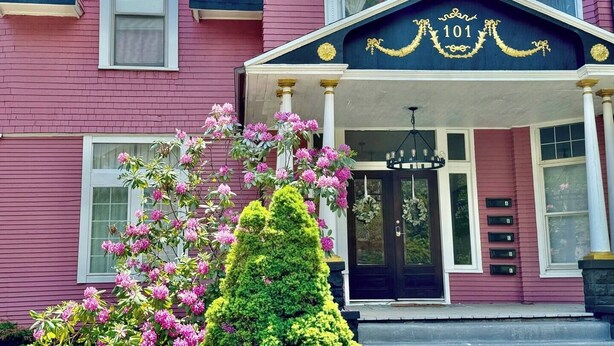 A pink building with a black entrance and a sign reading "101". - Birthday Suite / 1 BD/1BA Apt in Holiday House (Evansville)