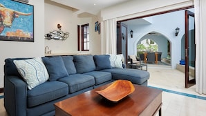 Ein modernes Wohnzimmer mit einem blauen Sofa, einem Holztisch und einem großen Gemälde eines Stiers.